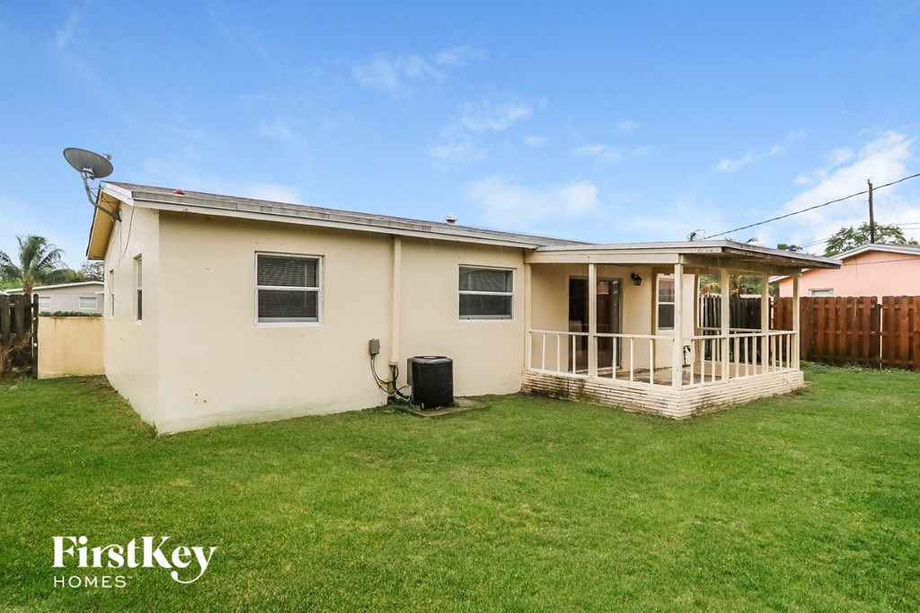a small white house with a yard and a porch