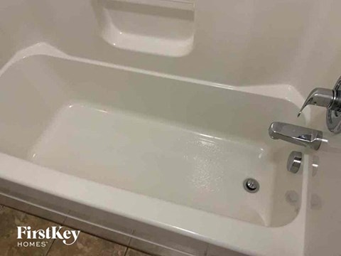 a white bath tub with two sinks in a bathroom