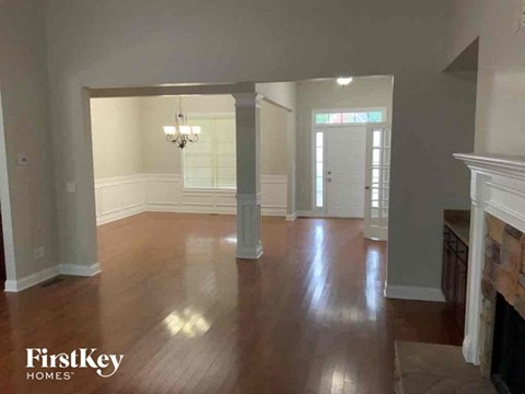 an empty living room with wood floors and a fireplace