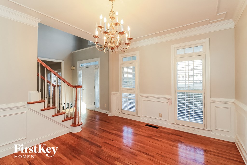 a living room with a staircase and a chandelier
