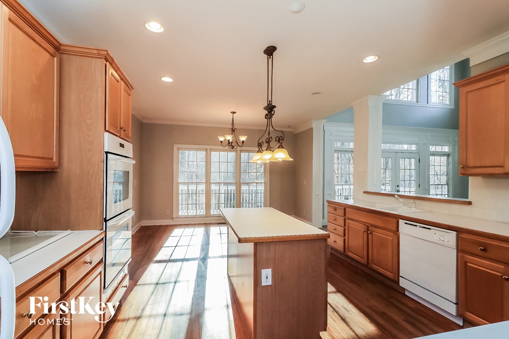 a kitchen with wooden cabinets and white appliances and a white counter top