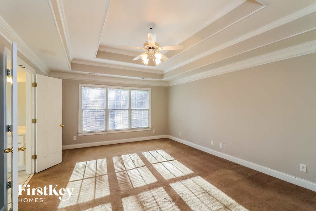 an empty living room with a ceiling fan and a window