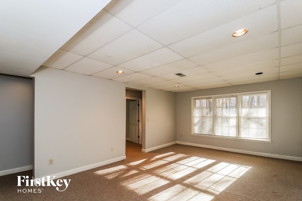 a living room with a large window and white ceilings