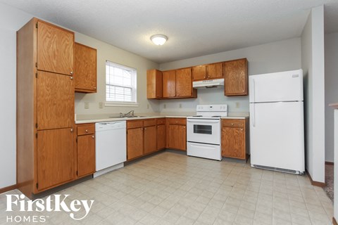 A kitchen with wooden cabinets and white appliances.