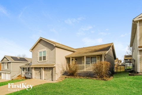 A house with a brown roof and a white garage door is for sale.