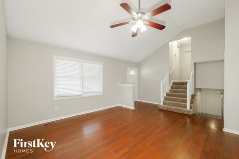 A room with a wood floor and a ceiling fan.