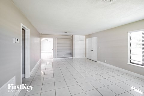 an empty living room with a tiled floor and a closet