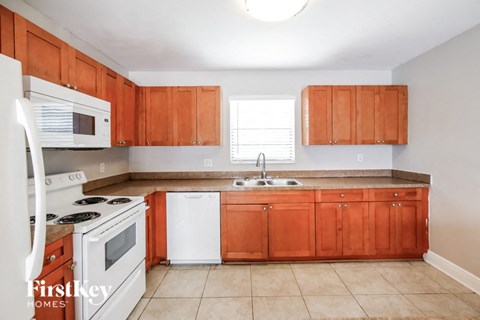 a kitchen with wooden cabinets and white appliances