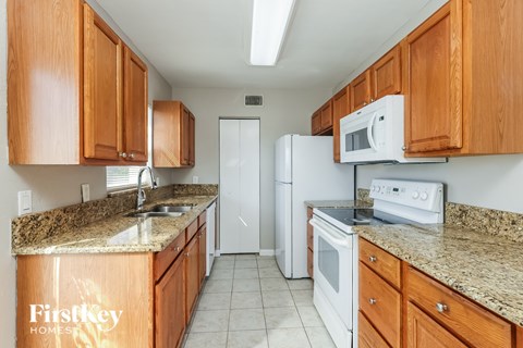 A kitchen with wooden cabinets and a granite countertop.