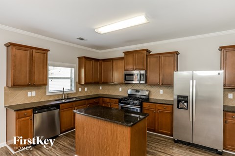A kitchen with wooden cabinets and a black countertop.