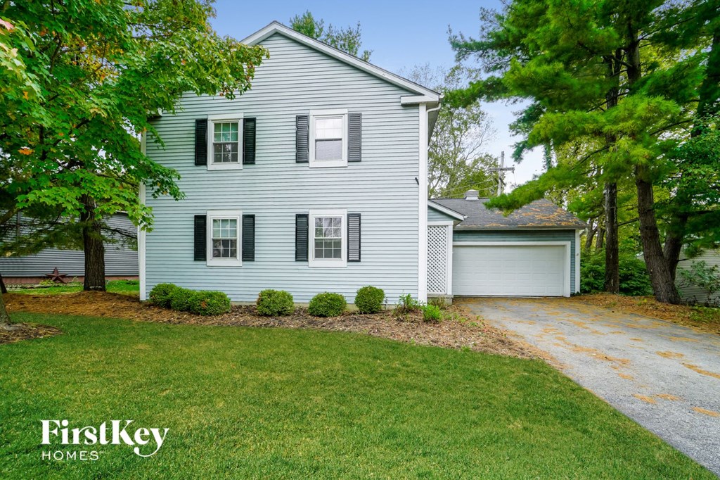a white house with black shutters and a driveway