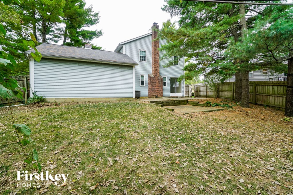 a backyard with a house and a fenced in yard
