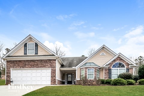 a brick house with a white garage door and a lawn