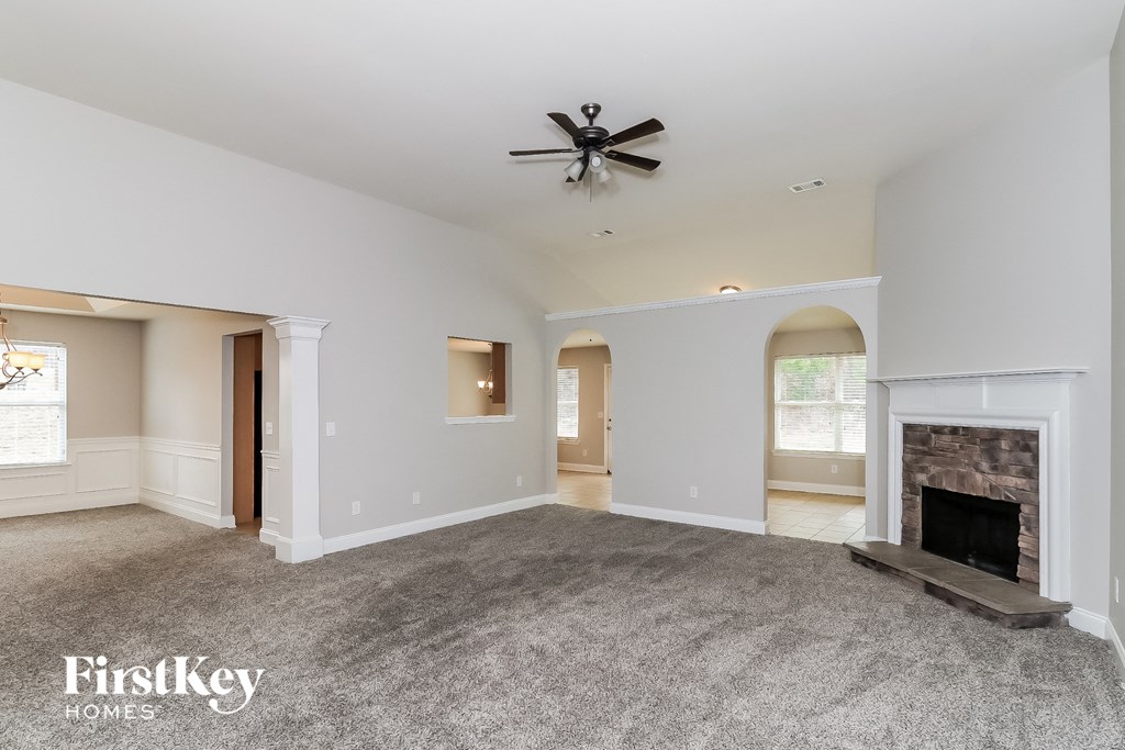 a living room with a fireplace and a ceiling fan