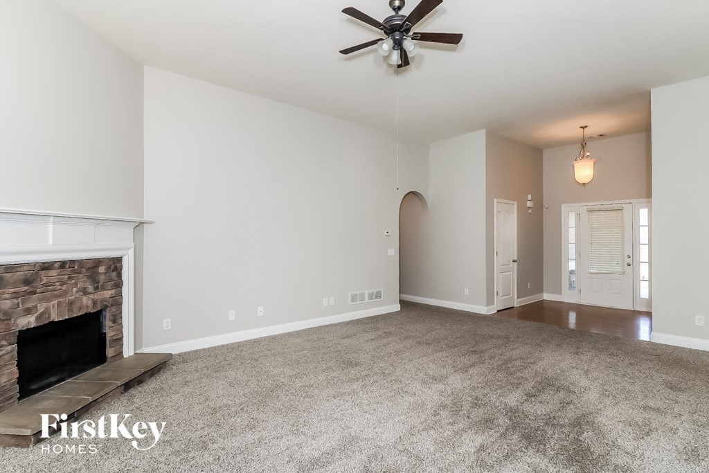 a living room with a fireplace and a ceiling fan