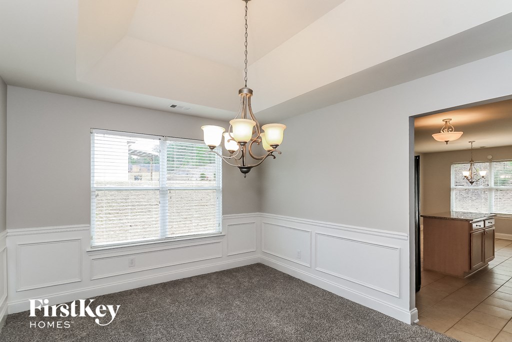 a dining room with a chandelier and a window