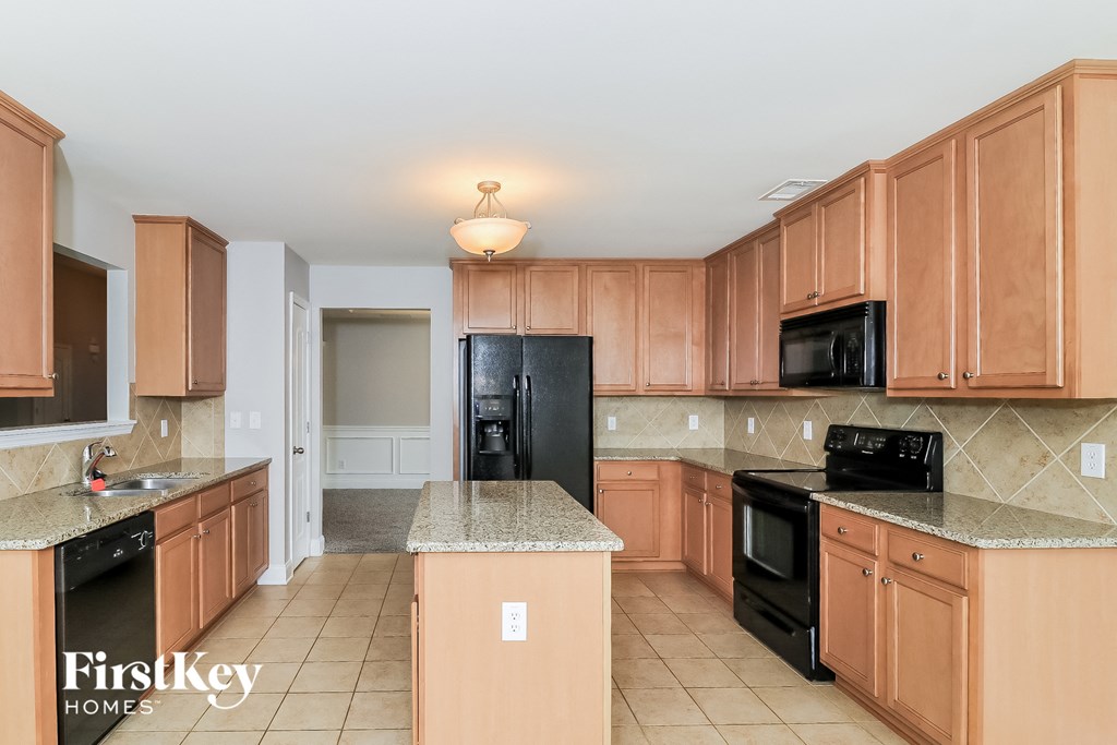 a large kitchen with wooden cabinets and black appliances