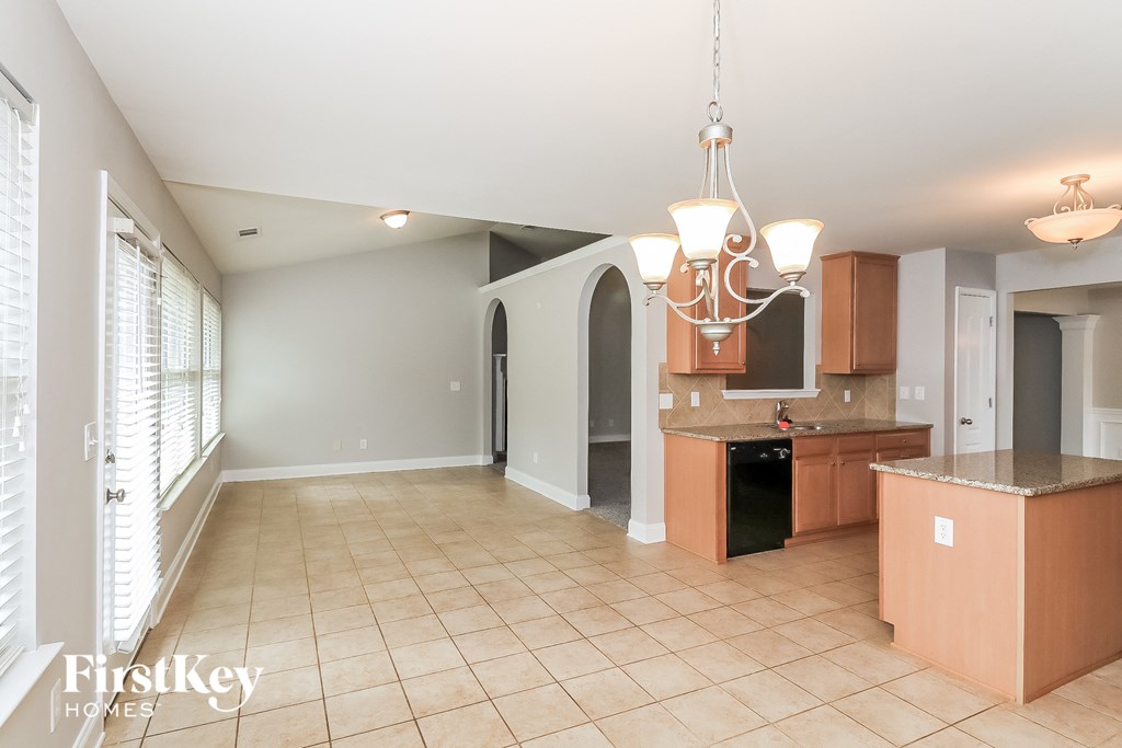 a kitchen and dining room with tile flooring and a chandelier