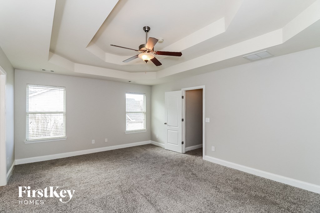 a bedroom with a ceiling fan and a door to a closet