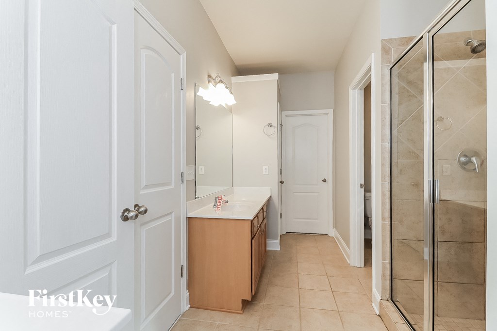 a bathroom with a shower and a sink and a mirror