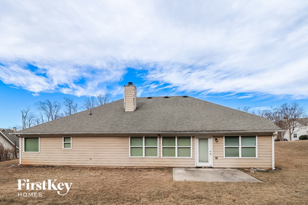 the front of a house with a cloudy sky in the background