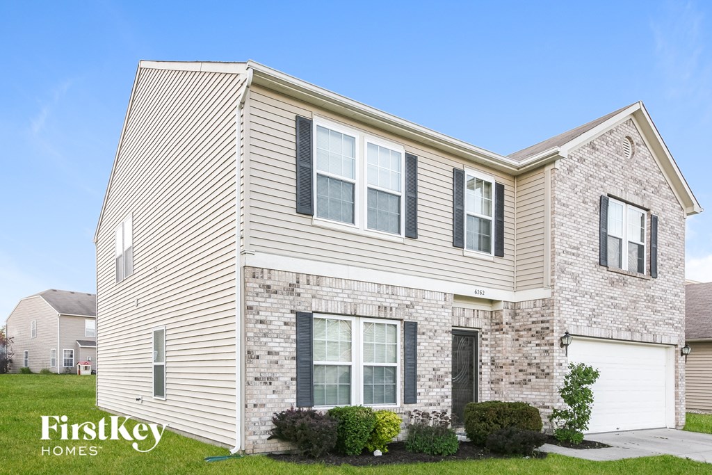 a brick house with white siding and gray bricks