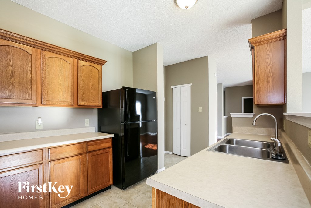 a kitchen with a sink and a black refrigerator