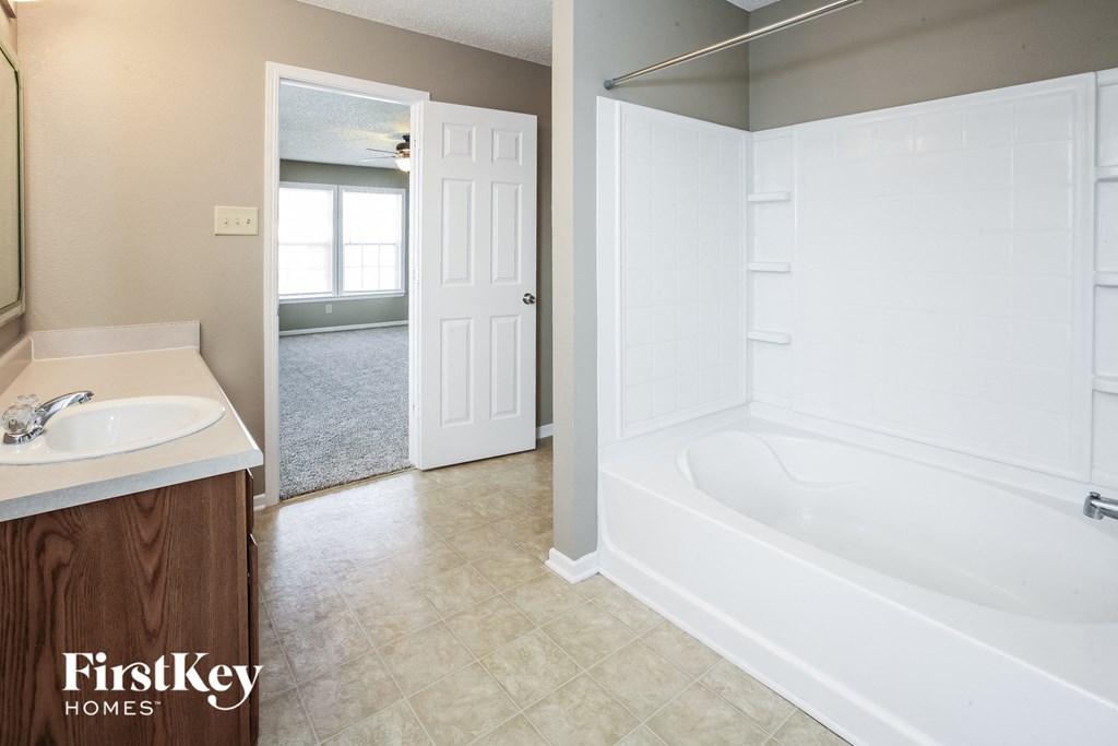 a bathroom with a tub and a sink and a mirror