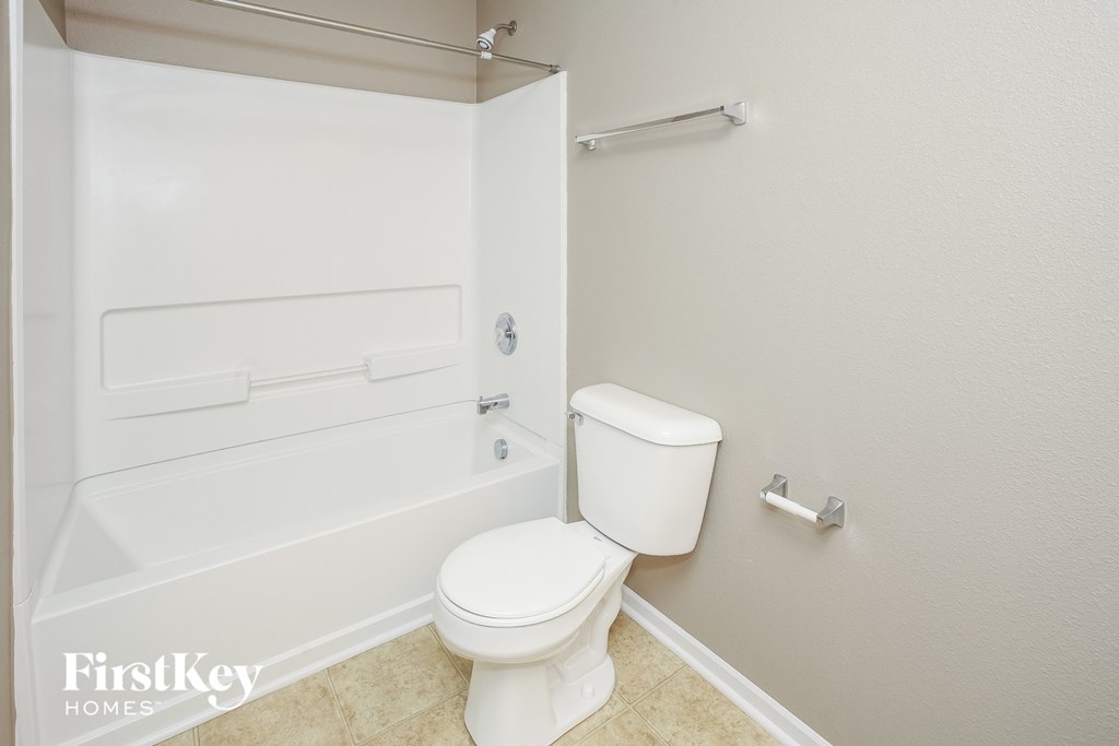 a bathroom with a toilet and a bath tub
