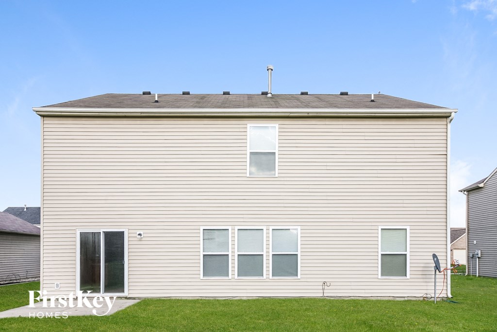 a white house with a gray roof on a green lawn