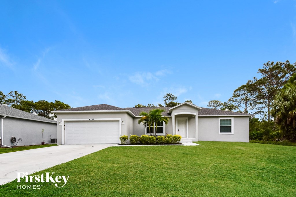 A house with a garage and a driveway is for sale.