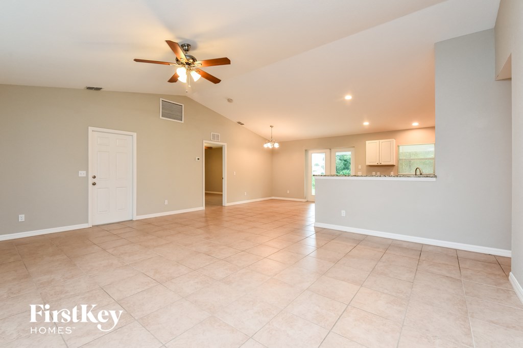 A spacious room with a ceiling fan and tiled flooring.