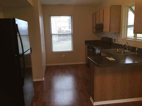 an empty kitchen with a sink and a refrigerator