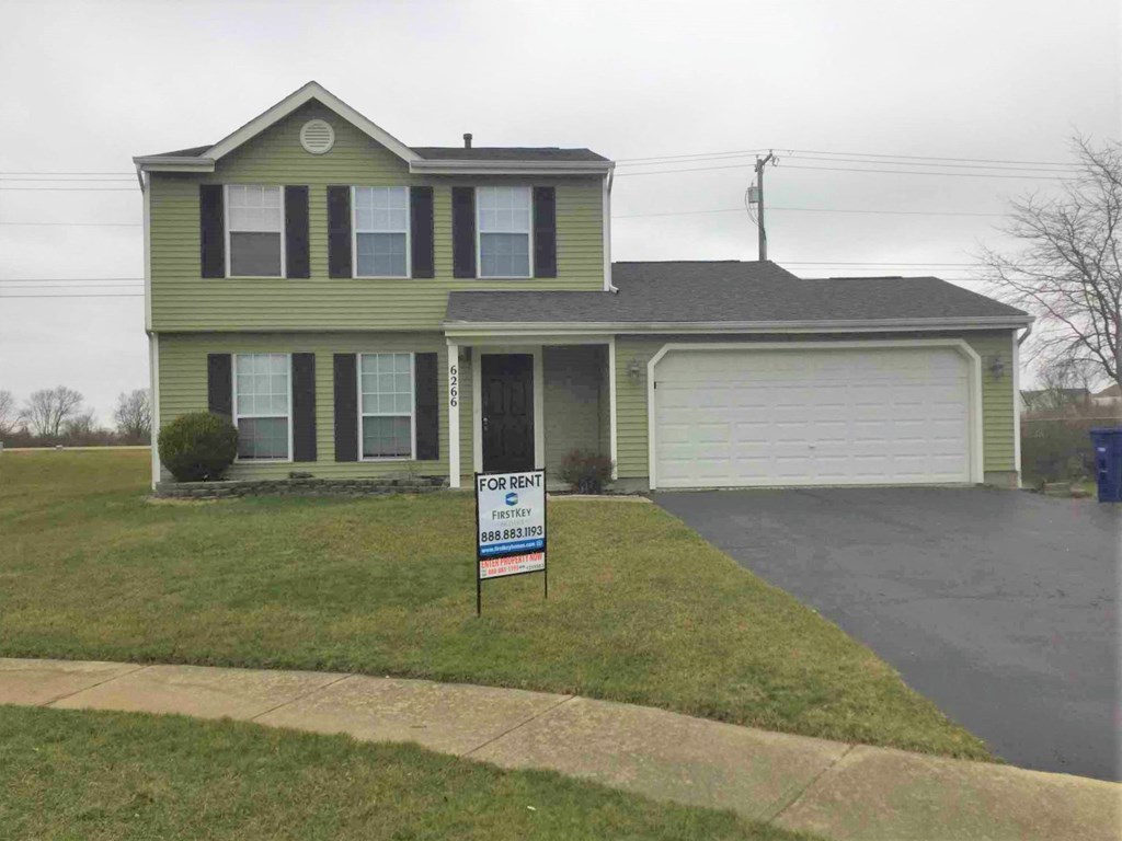 a house with a for sale sign in front of it