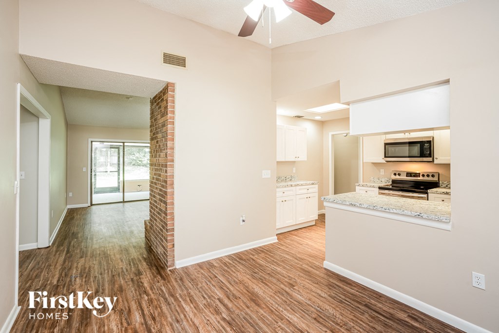an open kitchen and living room with hardwood flooring and a fireplace