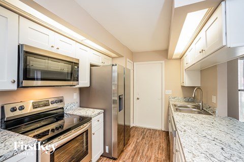 a kitchen with granite counter tops and stainless steel appliances