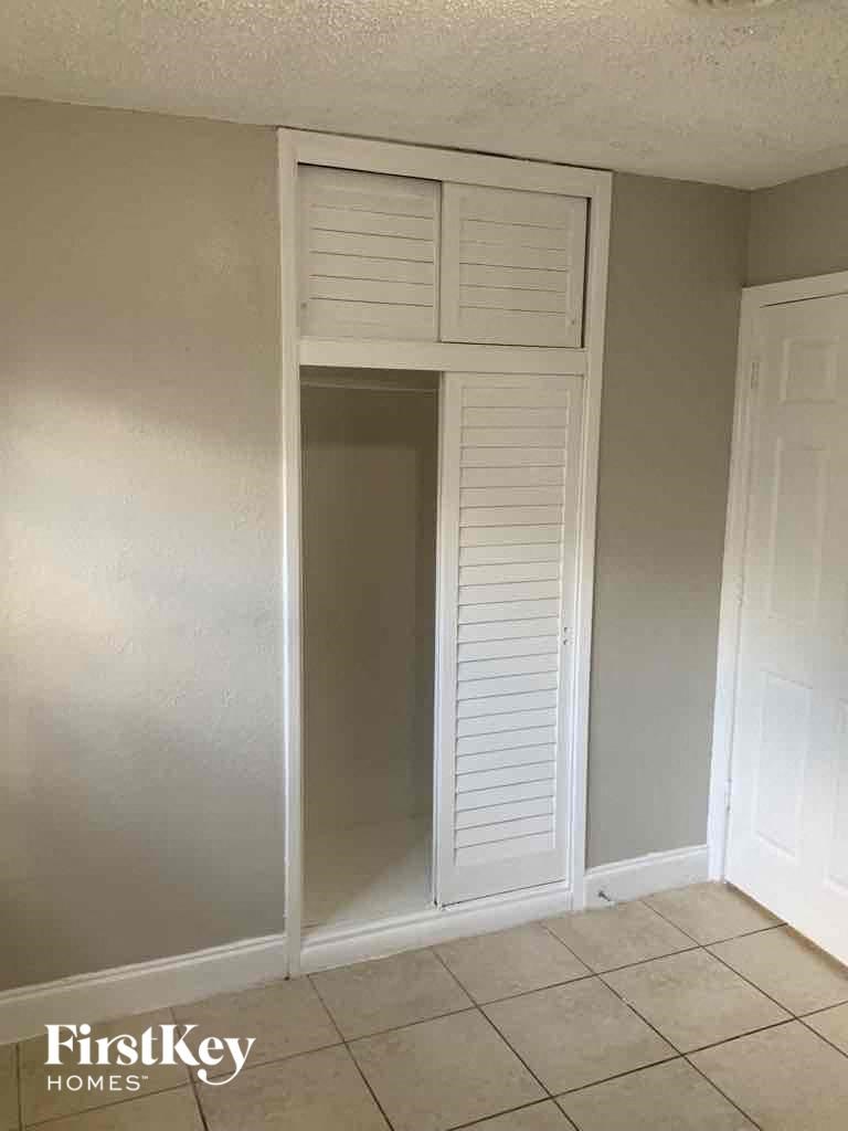 a closet with white shutters and a door to a closet