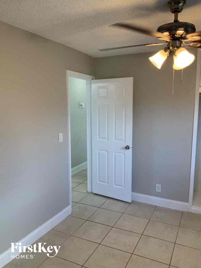 an empty room with a ceiling fan and a closet