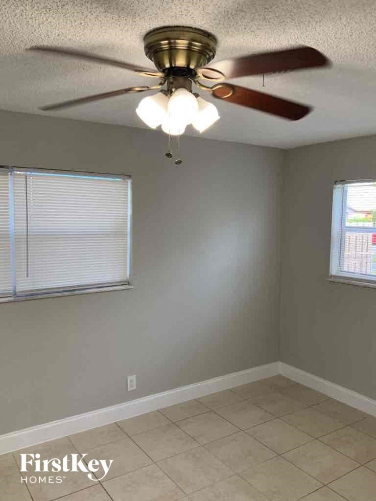 a bedroom with a ceiling fan and a tiled floor