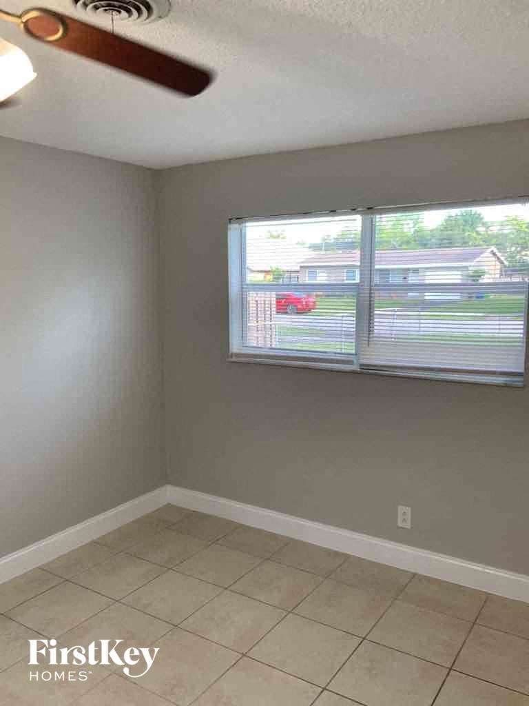 an empty room with a window and a tiled floor