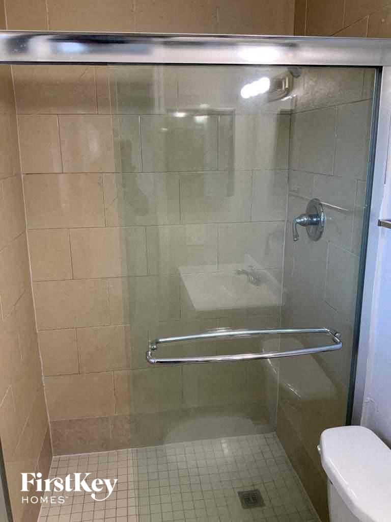 a bathroom with a shower with a glass door
