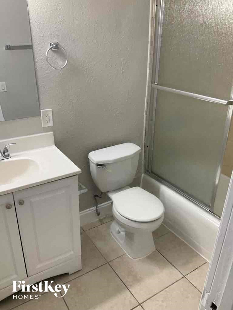 a bathroom with a toilet and a sink and a shower