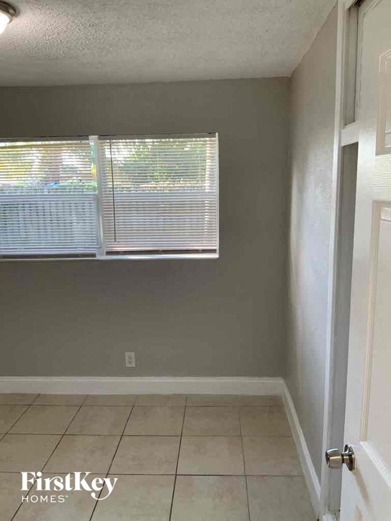 an empty room with a window and a tiled floor