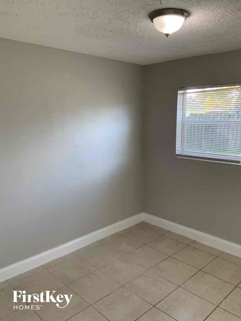 an empty room with a window and a tiled floor