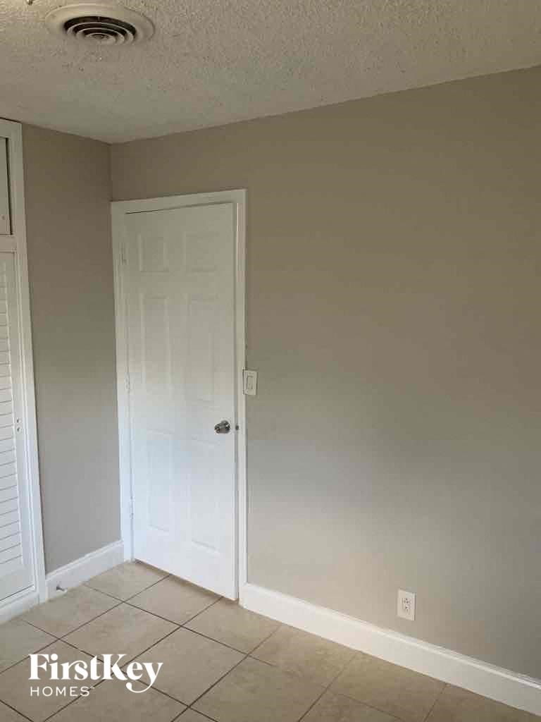 an empty room with a white door and a tiled floor
