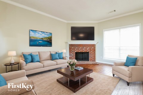 A living room with a fireplace and a painting on the wall.