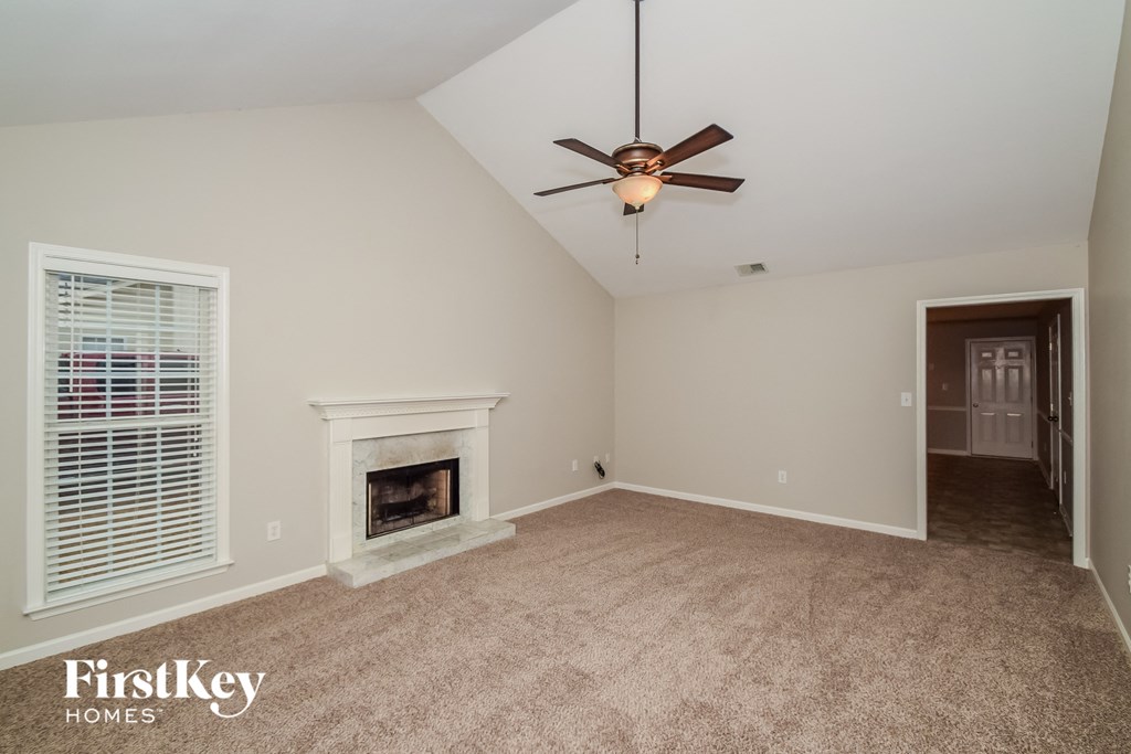 A room with a fireplace and a ceiling fan.