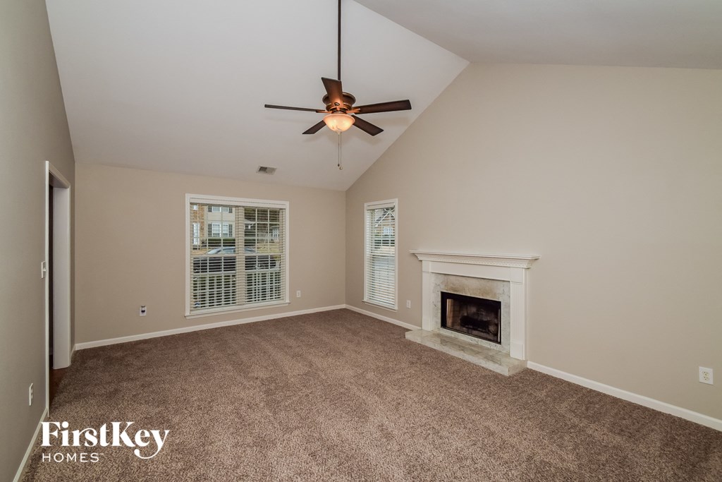 A room with a fireplace and a ceiling fan.