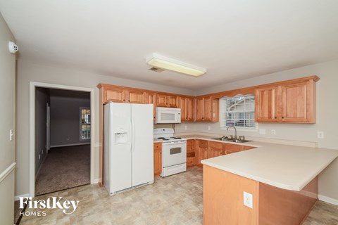 A kitchen with wooden cabinets and a white refrigerator.