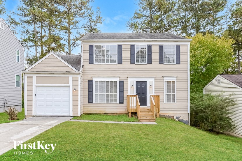 a white house with a yard and a deck in front
